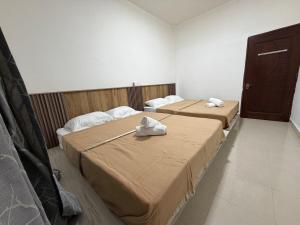 two beds in a hotel room with towels on them at AmaniStay Cameron Highlands in Cameron Highlands