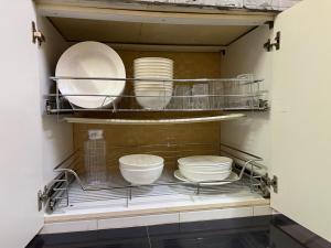 a kitchen with plates and bowls on a shelf at AmaniStay Cameron Highlands in Cameron Highlands +42 photos