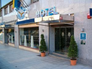 a building with two potted trees in front of it at Alda Estación Oviedo in Oviedo +18 photos