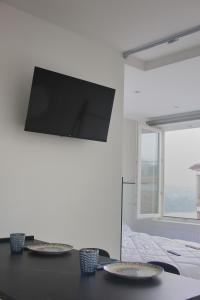 a black table with two plates and a tv on a wall at Apartamentos Dulce Estrela in Tui