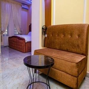 a room with a couch and a table and a bed at Tomfrank Hotel in Ado