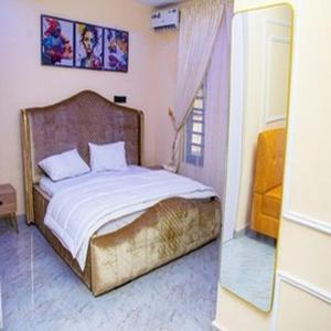 a bedroom with a large bed with a mirror at Tomfrank Hotel in Ado