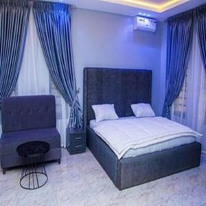 a bedroom with a bed and a chair at Tomfrank Hotel in Ado