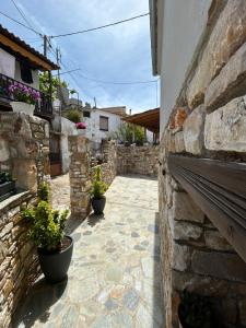 a stone alley with potted plants on the side of a building at Soleil House Thassos in Kallirákhi