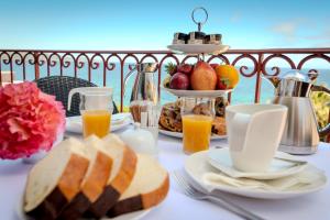 a table with a breakfast of bread and orange juice at Hôtel Demeure Loredana in Saint-Florent