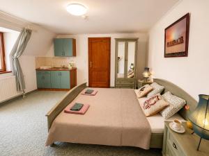 a bedroom with a large bed and a kitchen at Éden Panzio in Bük