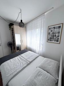 a bedroom with a bed with white sheets and a window at Apartment Rose in Sesvete
