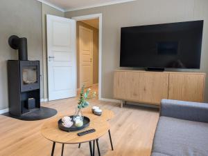a living room with a couch and a tv and a table at Leilighet på Voss in Vossevangen