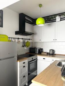 a kitchen with white cabinets and a stove top oven at Apartment Rose in Sesvete