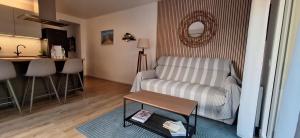 a living room with a couch and a table at 3 pièces avec terrasse arborée in Arcachon