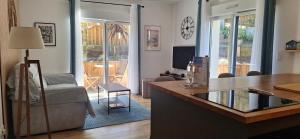 a living room with a table and a living room with a couch at 3 pièces avec terrasse arborée in Arcachon