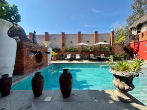 a swimming pool with three vases on a patio at Casa Miura Hotel Boutique in Ajijic