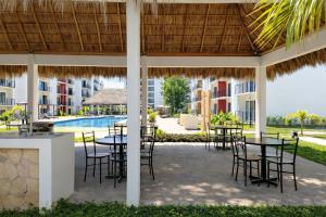 a patio with tables and chairs and a swimming pool at Modern apartment with pool , Riviera Nayarit in Naranjo