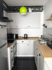 a kitchen with white cabinets and a yellow light fixture at Apartment Rose in Sesvete +12 photos