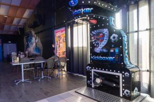 a video game machine in a restaurant with a table at Cit'Hotel Restaurant du Bowling de Millau in Millau