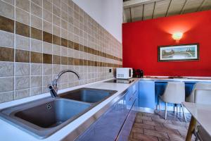 a kitchen with a sink and a red wall at Romeo Giulietta in Verona