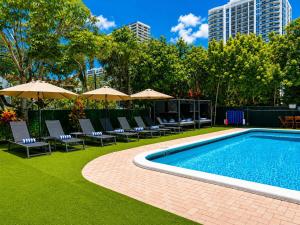 a swimming pool with chairs and umbrellas in a city at Ocean Beach Club in Fort Lauderdale