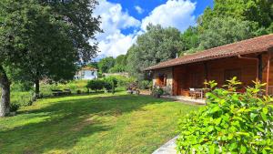 a log cabin with a yard next to a house at Casa das Devesas in Caldelas