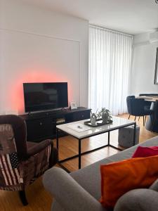 a living room with a tv and a couch and a table at Apartment Rose in Sesvete