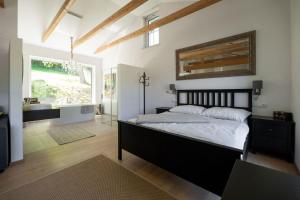 ein Schlafzimmer mit einem großen Bett und ein Badezimmer in der Unterkunft WaldLoft - Südsteiermark in Heimschuh