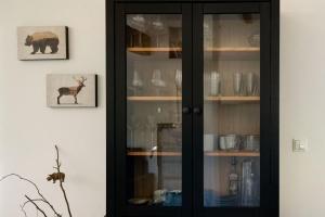 ein schwarzer Schrank mit Glastüren in einem Zimmer in der Unterkunft WaldLoft - Südsteiermark in Heimschuh