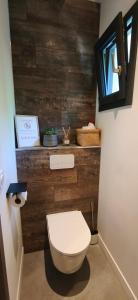 a bathroom with a toilet and a wooden wall at Gîte des Bartavelles in Saint-Didier +25 photos