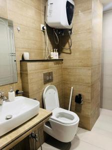 a bathroom with a white toilet and a sink at Seven Star Heights in Rawalpindi +36 photos