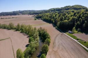 eine Luftaufnahme eines Feldes und eines Flusses in der Unterkunft WaldLoft - Südsteiermark in Heimschuh