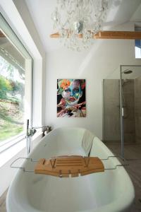 eine Badewanne in einem Badezimmer mit einem Kronleuchter in der Unterkunft WaldLoft - Südsteiermark in Heimschuh