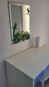 a mirror on a wall next to a white table at Casa Irene in Villasimius
