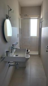 a bathroom with a sink and a mirror and a shower at Casa Irene in Villasimius