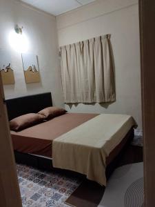 a small bedroom with a bed and a window at Tipika Room Pasir Pekan in Tumpat