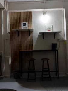 a bar in a room with two stools and a light at Tipika Room Pasir Pekan in Tumpat