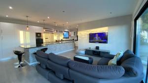 a living room with a large couch and a kitchen at A Casa do Góis - Villa in Porto Santo in Porto Santo