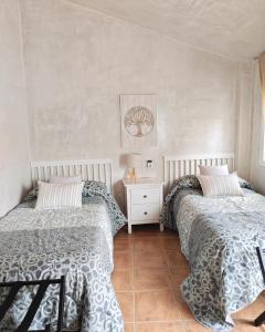 a bedroom with two beds and a tiled floor at Entre Vistas in Zahara de la Sierra