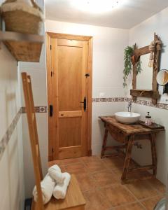 a bathroom with a sink and a wooden door at Entre Vistas in Zahara de la Sierra +46 photos