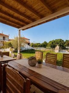 a wooden table and chairs on a patio at Venice Studios & Apartments in Stavros