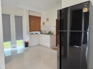a kitchen with a black refrigerator in a room at Villa Solara in Ko Phangan