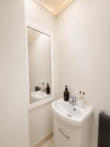 a white bathroom with a sink and a mirror at Blue Mountains charm with Spa! in Wentworth Falls +52 photos