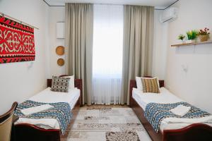 a room with two beds and a window at Apple Hostel Bishkek in Bishkek