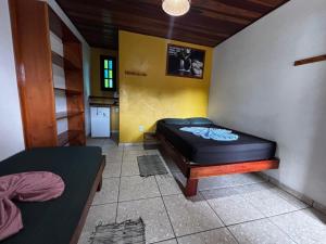 a room with a bed in the corner of a room at Pousada Figueira in Trindade