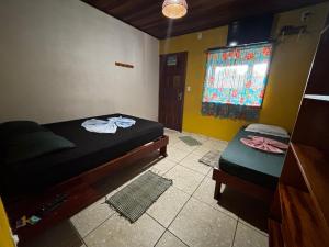 a small room with two beds and a window at Pousada Figueira in Trindade