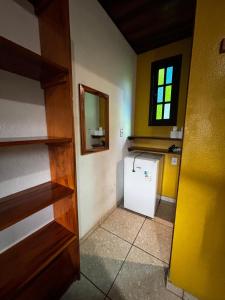 a kitchen with a small refrigerator and a window at Pousada Figueira in Trindade