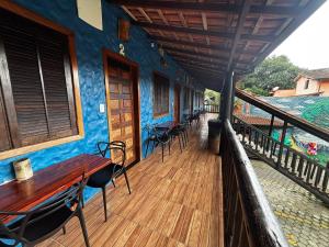 a wooden deck with tables and chairs on a house at Pousada Figueira in Trindade +82 photos
