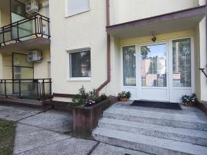 a white front door of a house with stairs at Erkel apartman in Harkány
