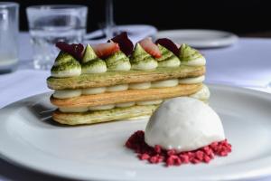 a stack of sandwiches with fruit on a white plate at The Ash Tree in Ashendon