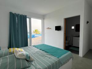 a bedroom with a bed with a view of the ocean at Cap-Azul in Porto Novo
