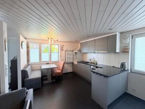 a kitchen with white cabinets and a counter top at Modern apartment with garden in Lostorf
