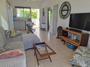a living room with a couch and a flat screen tv at ATLANTIS Penthouse Apartment with Jacuzzi plus Pool and Sea Views in Peyia