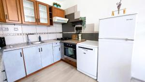 a kitchen with white cabinets and a white refrigerator at Metro Budějovická apartment in Prague